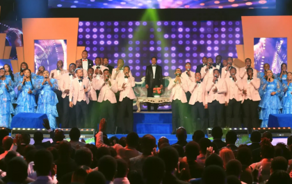 Men and women are standing on the stage. of Praise Night with Pastor Chris